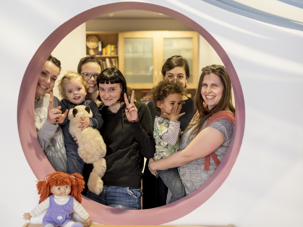 Gruppenfoto mehrerer Familien mit kleinen Kindern auf der Familienetage des Familienzentrums – ein Ort der Begegnung, Gemeinschaft und frühkindlichen Förderung.