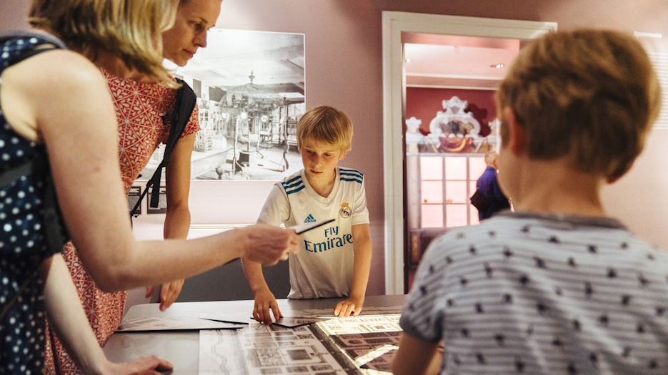 Zwei Frauen und zwei Kinder puzzeln an einer Mitmachstation der Jahresausstellung zur Kunst- und Naturalienkammer. 