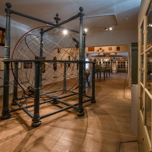 Innenansicht der Kunst- und Naturalienkammer der Franckeschen Stiftungen mit zentralem Weltenmodell und historischen Sammlungsschränken der barocken Wunderkammer.