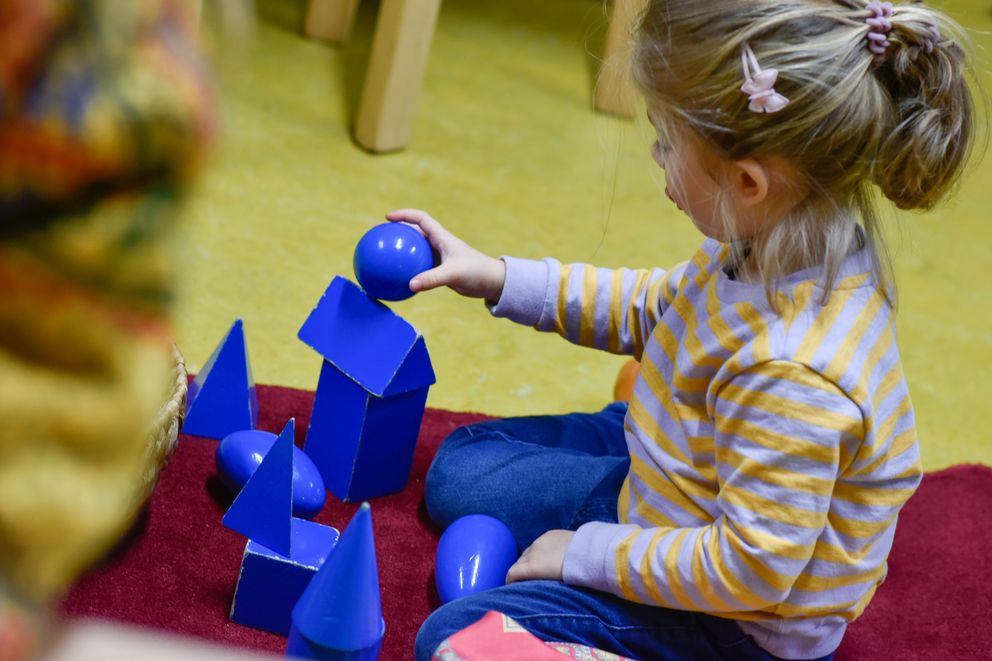 Ein Kind spielt mit blauen Bausteinen