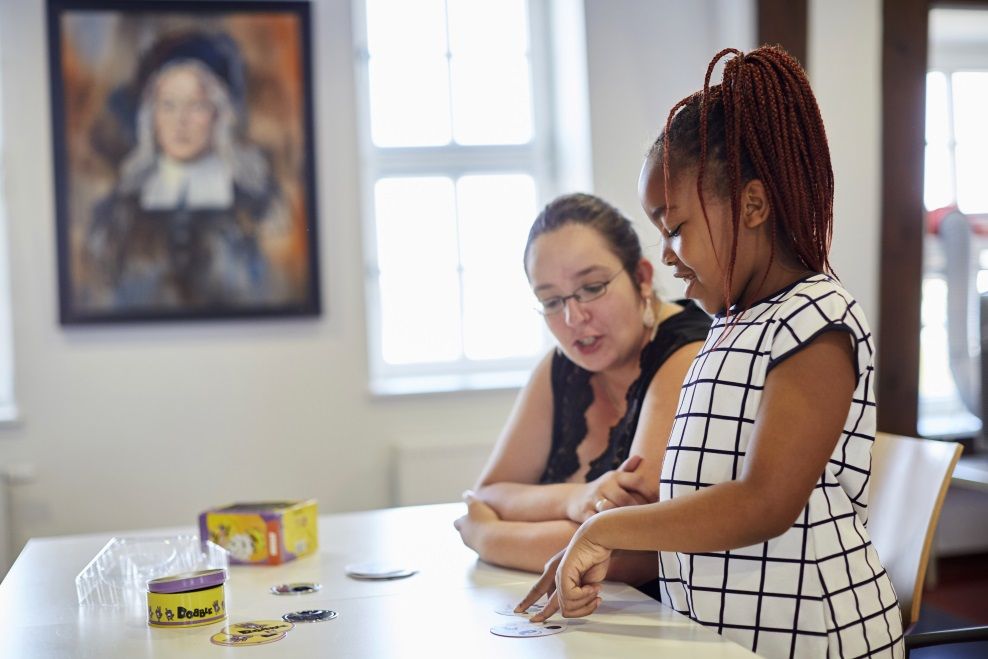 Eine Frau hilft einem Mädchen beim Lernen
